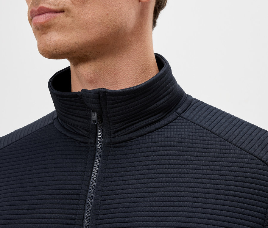 Gros plan d'un homme portant une veste bleu marine zippée à col montant.