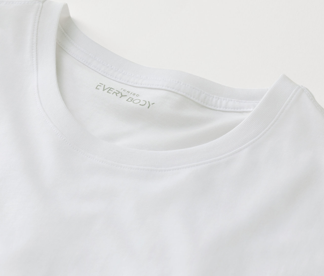 Gros plan d'un t-shirt blanc avec l'inscription EVERY BODY.