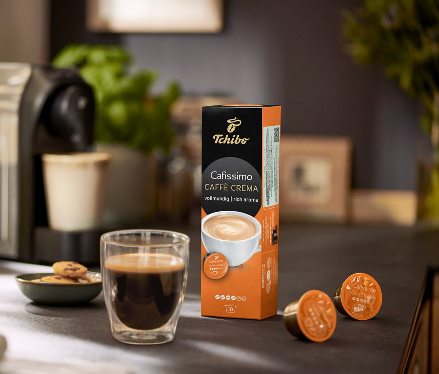 Machine à café avec tasse de café, biscuits et paquet de Cafissimo Caffè Crema vollmundig (intense) – 10 capsules.