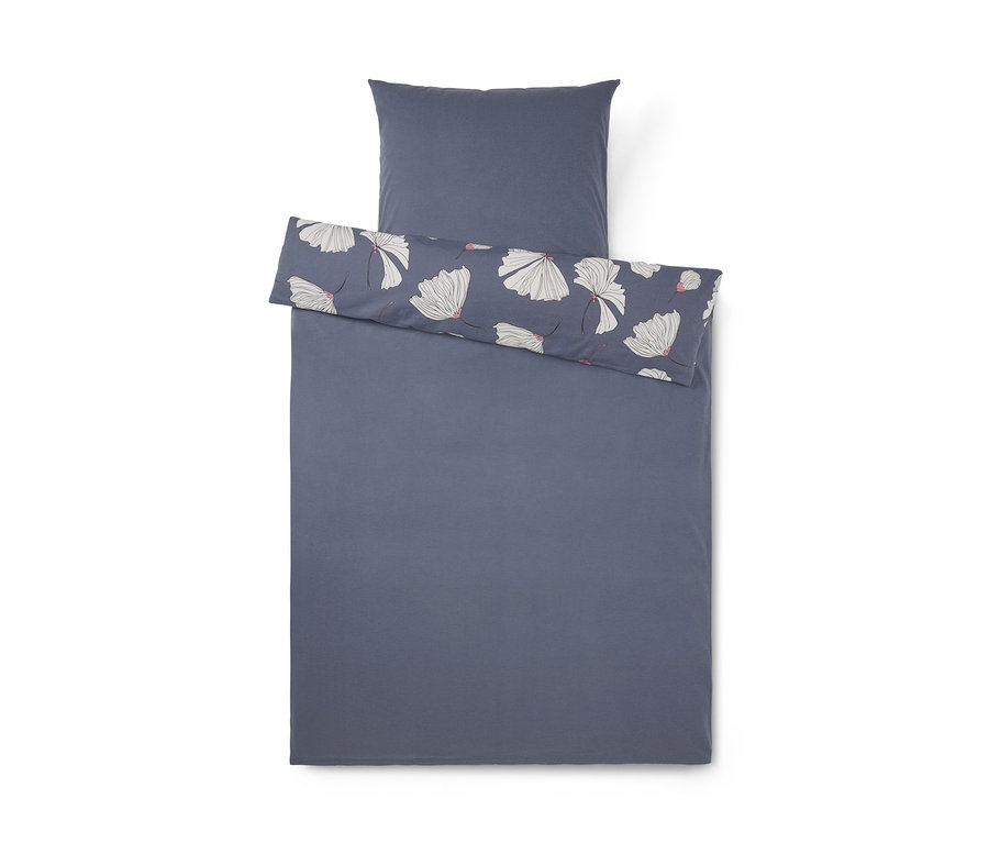 Parure de lit bleu-gris foncé avec une taie d'oreiller et une housse de couette. La housse de couette est pliée pour révéler un motif floral blanc avec des centres roses, assorti à la taie d'oreiller.
