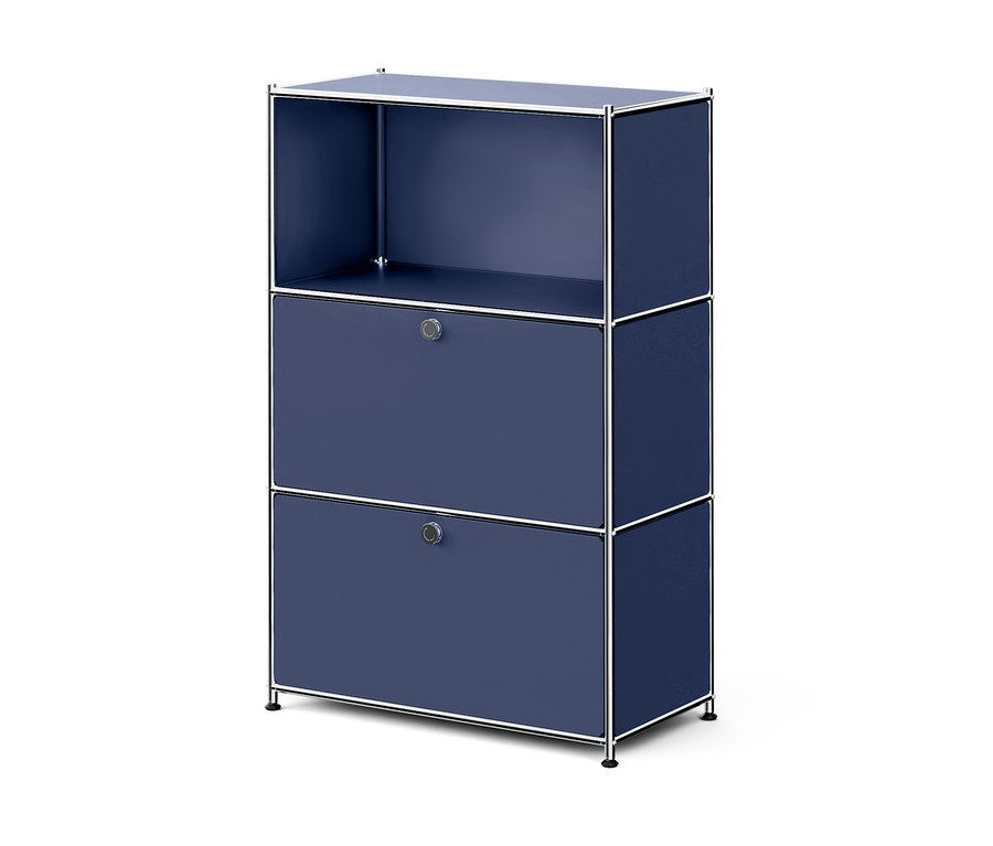 Meuble modulaire bleu foncé avec cadre en métal chromé. Il comporte trois sections : une étagère ouverte en haut et deux sections inférieures avec des portes abattantes, chacune avec une poignée ronde argentée. Le meuble repose sur de petits pieds noirs.