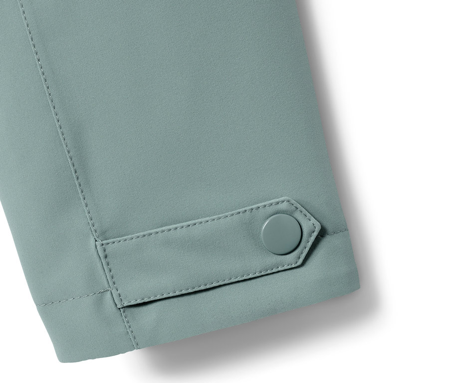 Gros plan sur la manche d'un trench-coat de pluie avec un bouton.