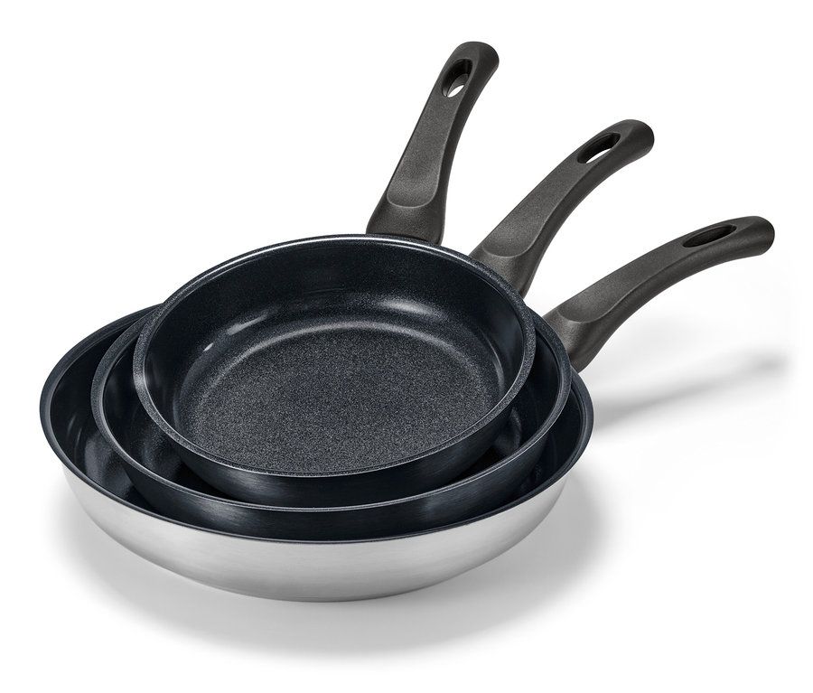 Trois poêles en inox avec revêtement en céramique de différentes tailles empilées les unes sur les autres.
