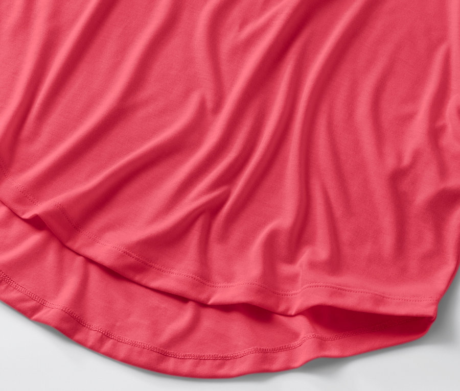 Détail d'un t-shirt long rose vif.