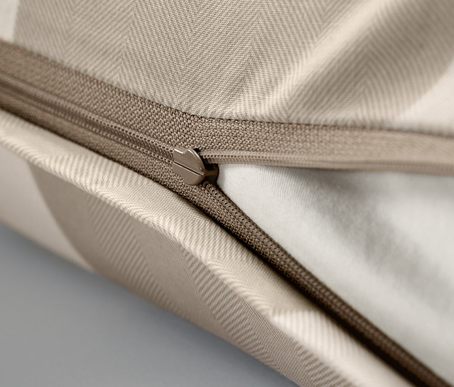 Gros plan d'une taie d'oreiller beige avec une fermeture éclair.