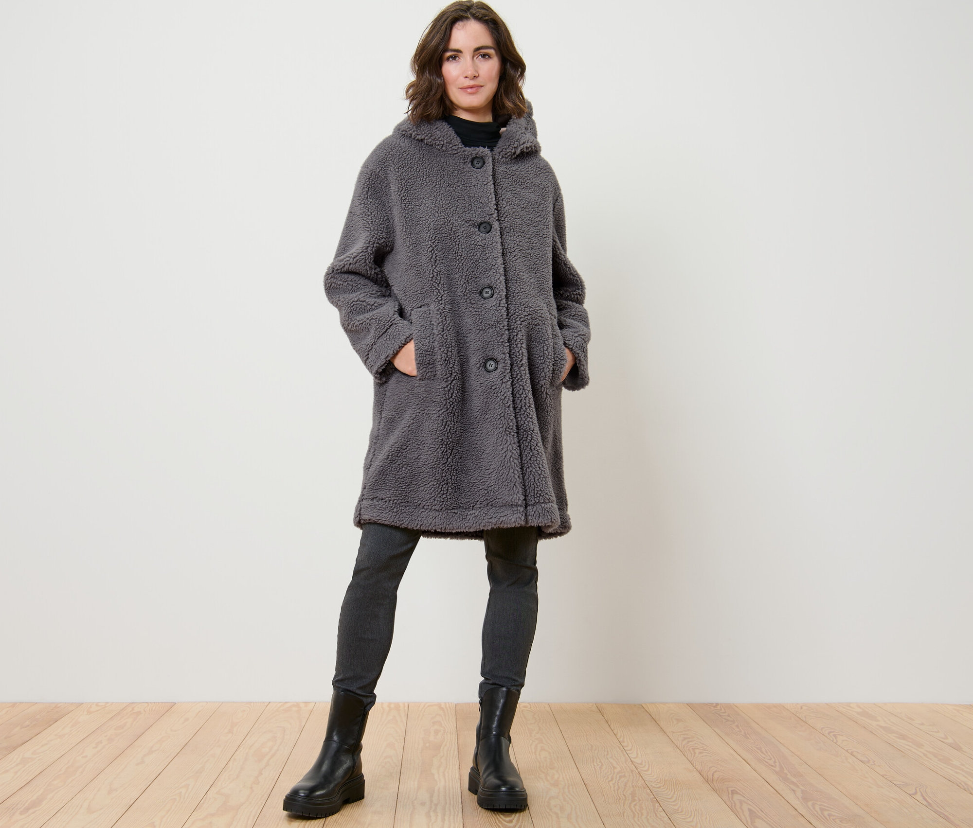 Femme posant dans un manteau en teddy avec capuche.