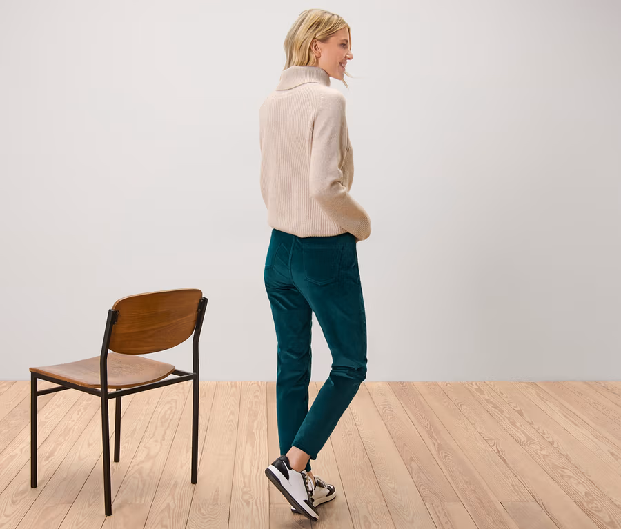Femme posant en pantalon en velours pétrole.