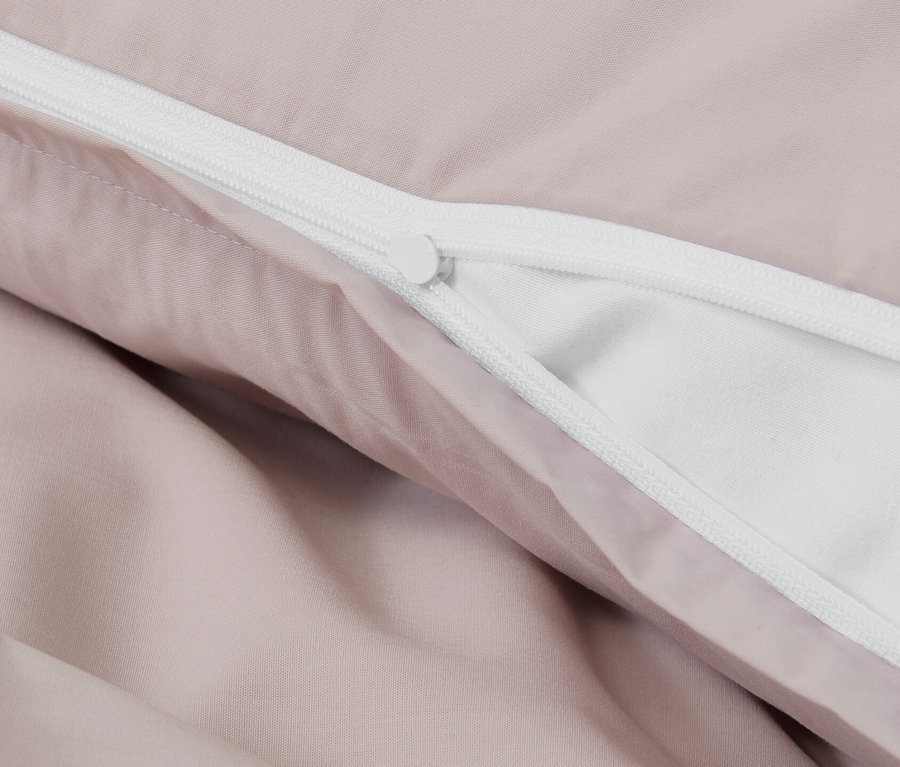 Détail de la parure de lit en percale rose avec fermeture éclair.
