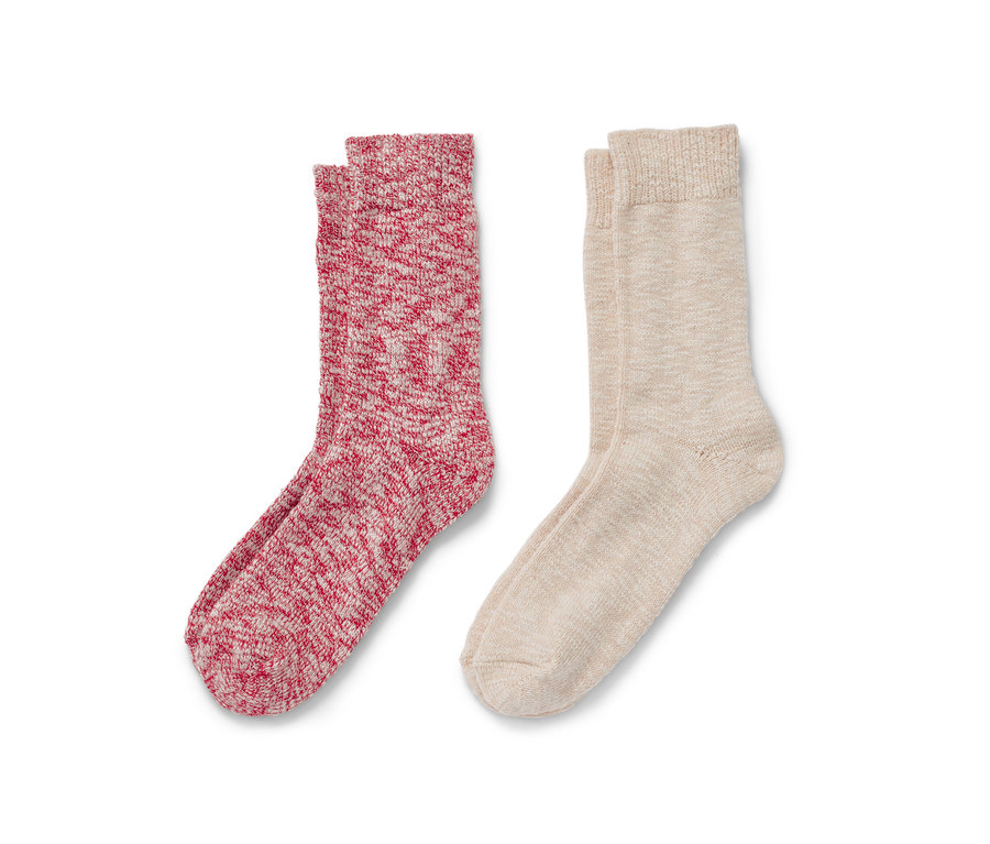 Deux paires de chaussettes en maille, une paire est rouge et blanche et l'autre beige.
