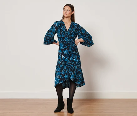 Femme posant dans une robe à imprimé.