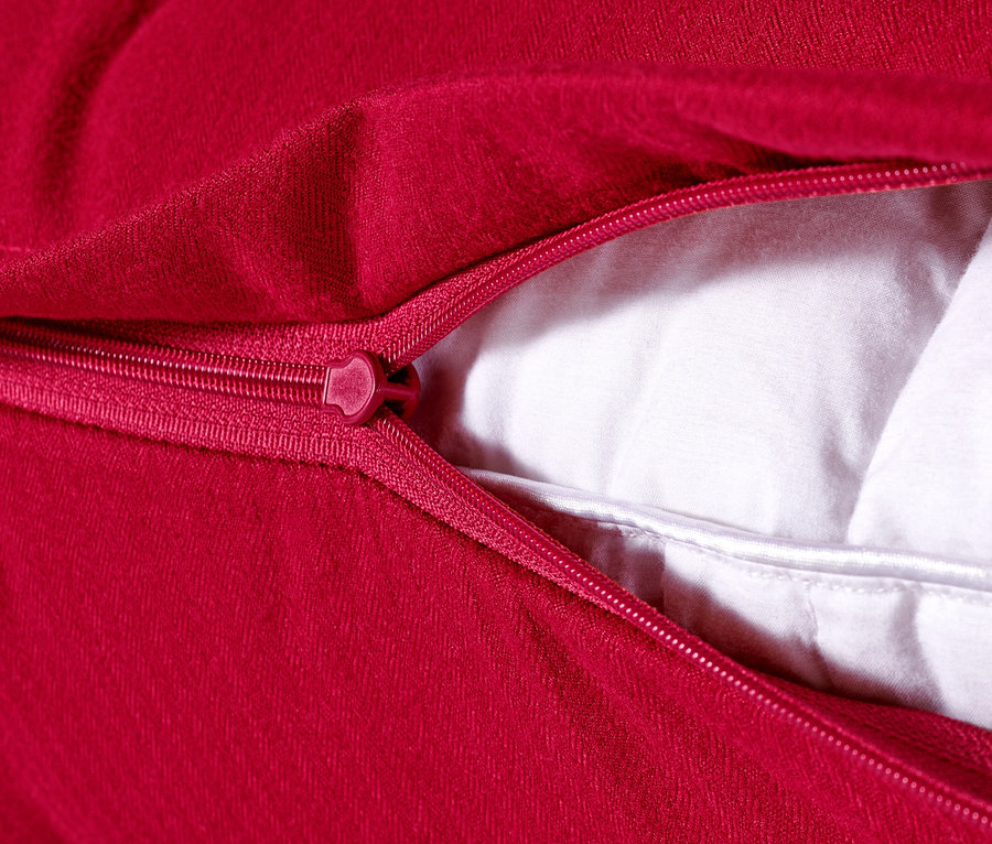 Gros plan sur 2 taies d’oreiller rouge en microfibre et flanelle avec fermeture éclair et rembourrage blanc.