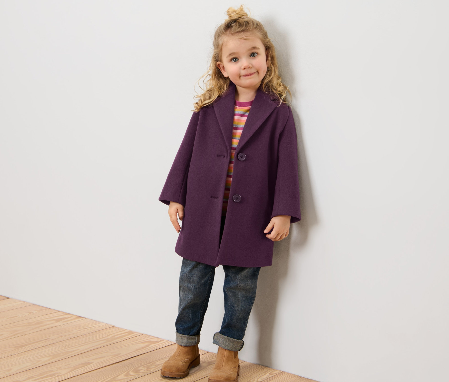 Fillette posant en manteau pour enfant.