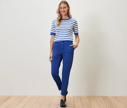 Femme posant en pantalon chino bleu cobalt et haut rayé.