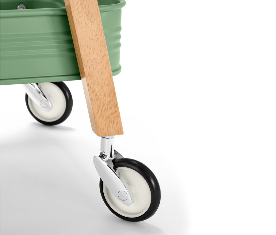Gros plan d'un chariot de service de cuisine avec dessus vert, poignée en bois et roues.