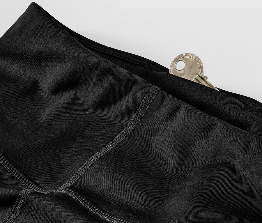 Détail d'un legging de sport noir avec une clé dans la poche.