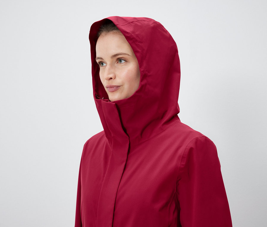 Une femme porte une veste rouge à capuche.