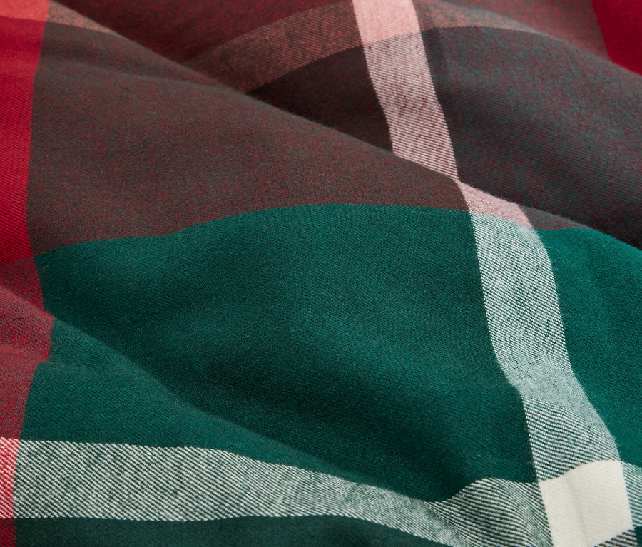 Gros plan sur un tissu à carreaux dans les tons vert, marron, rouge et blanc.