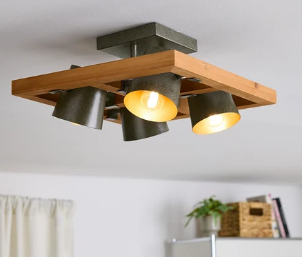 Plafonnier avec cadre en bois et quatre spots gris.
