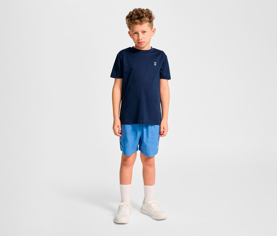 Garçon portant un short bleu et un t-shirt d’entraînement bleu foncé HUMMEL HMLJR pulse.