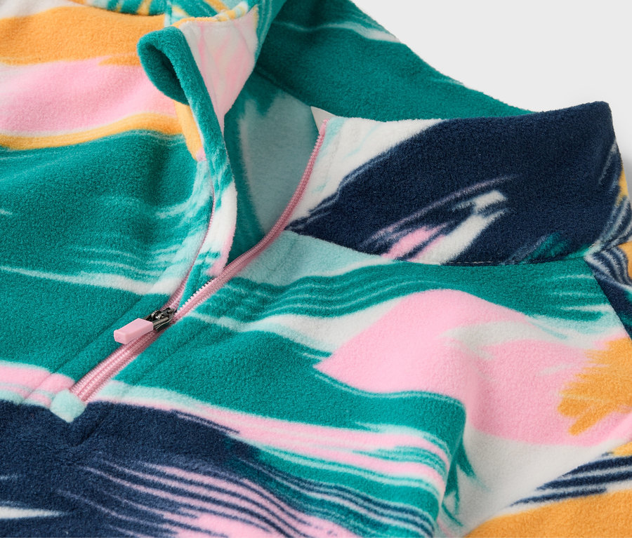 Gros plan sur un pull en polaire à motifs avec une courte fermeture éclair.