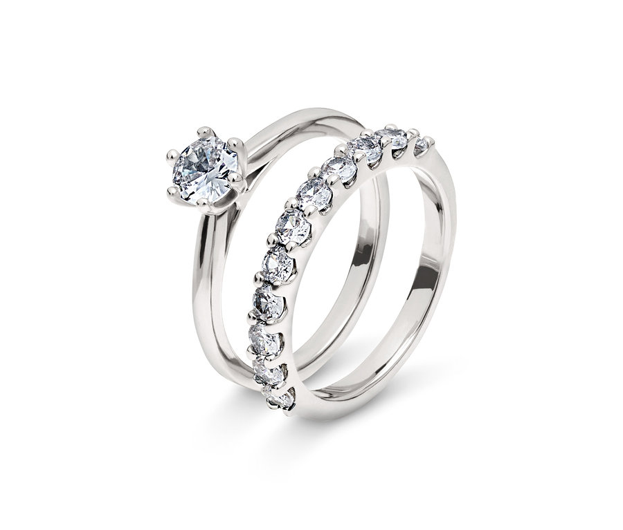Deux anneaux argentés, un avec un seul diamant, l'autre avec une rangée de diamants.