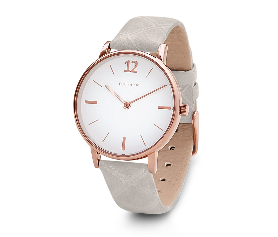 Gros plan sur une montre-bracelet avec un bracelet en cuir, un cadran blanc et un boîtier en or rose.