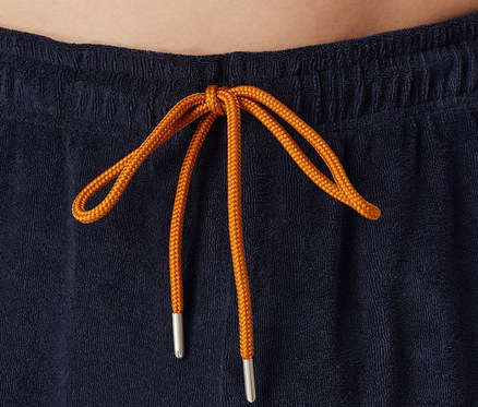 Gros plan sur un short bleu marine avec un cordon de serrage orange.