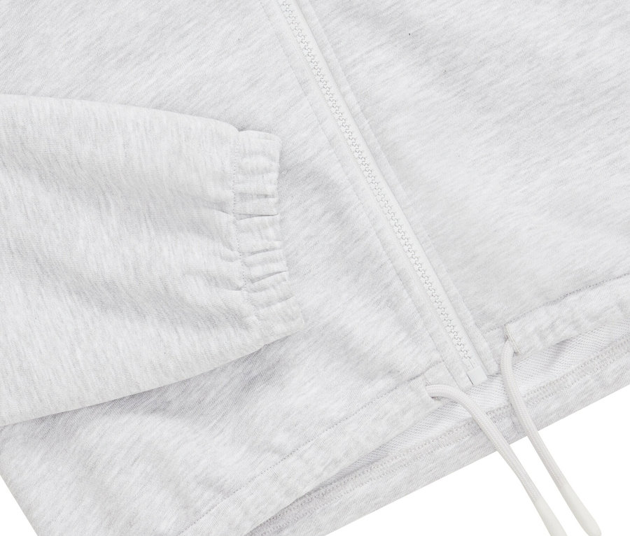 Gros plan sur un sweat-shirt de sport gris avec fermeture éclair et cordon de serrage.