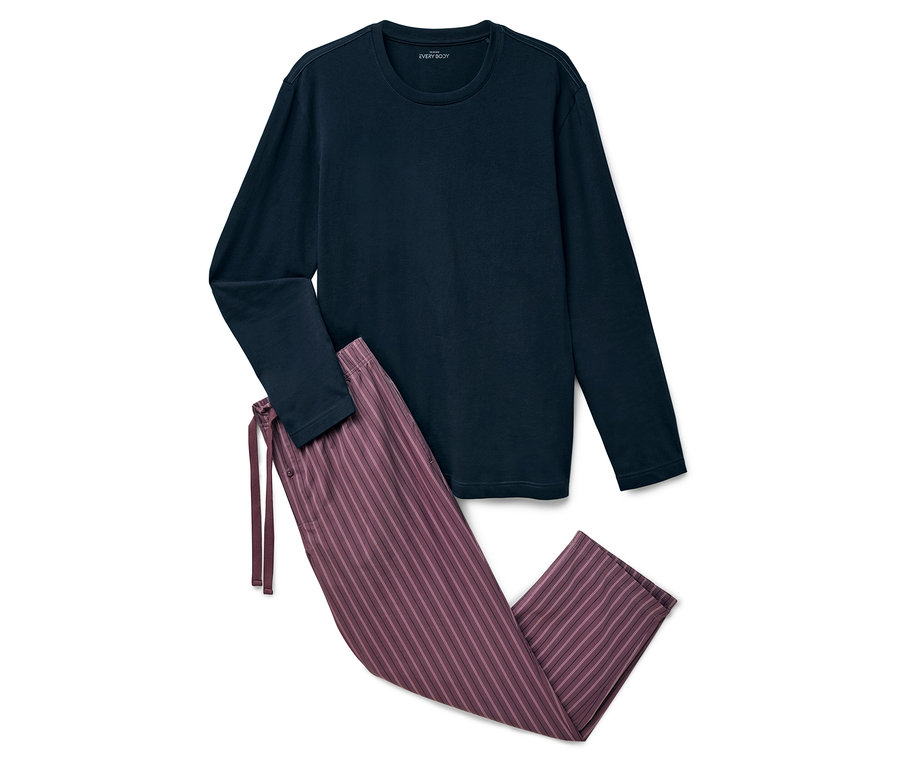 Un haut de pyjama bleu marine à manches longues et un pantalon violet rayé sont posés sur un fond blanc.
