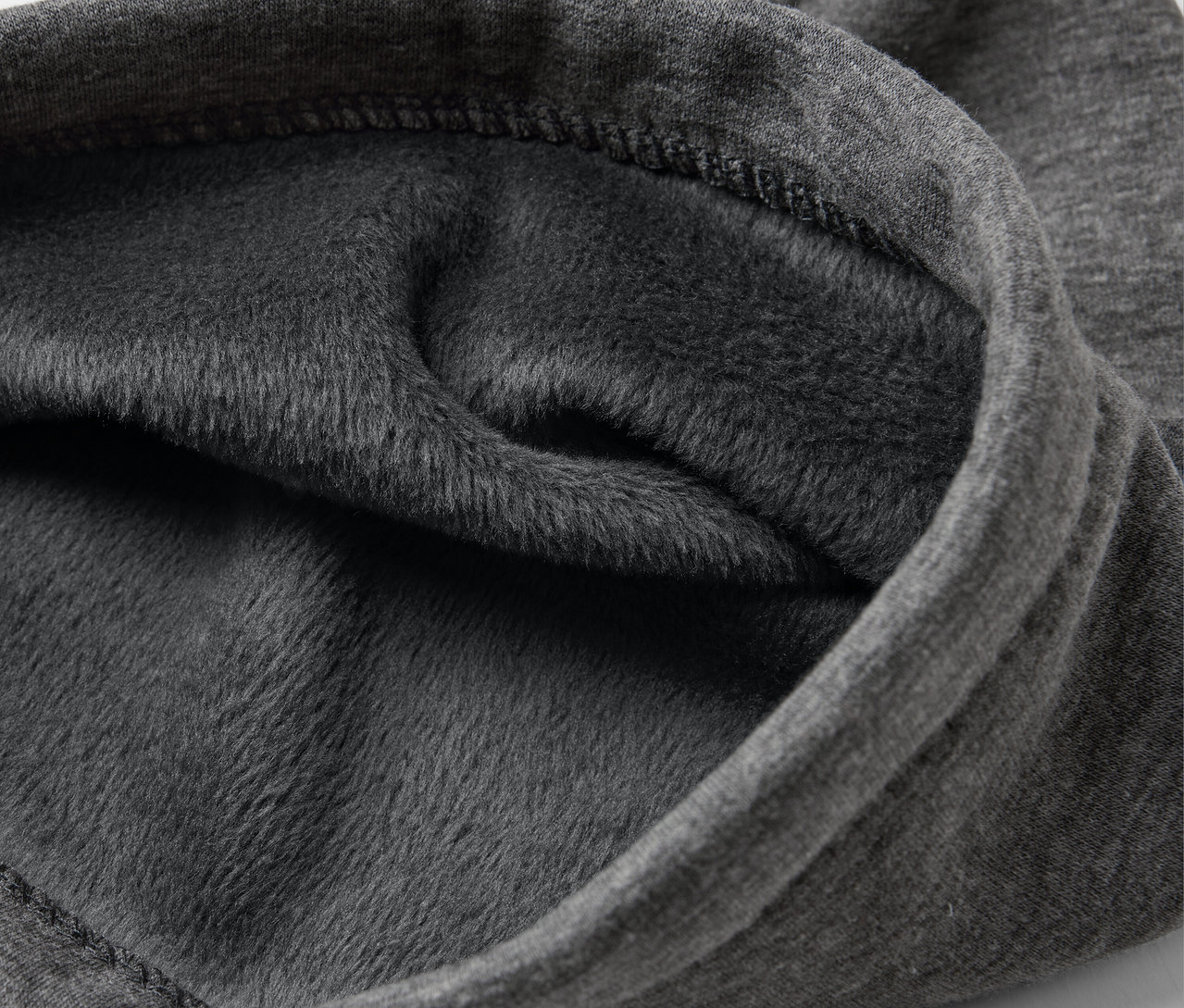 Gros plan d'un tissu gris avec une doublure en polaire.