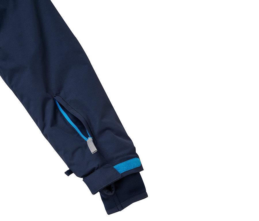 Détail de la manche d'une veste avec poche zippée et ourlet bleu.