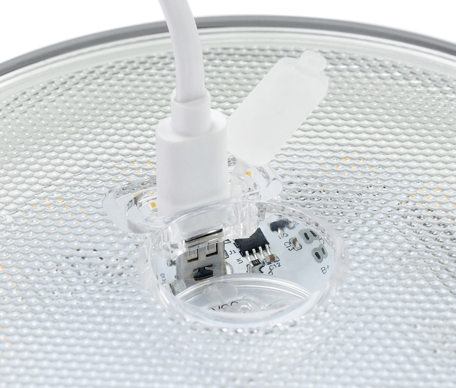 Gros plan d'un connecteur USB blanc branché sur une prise transparente avec des composants électroniques visibles.