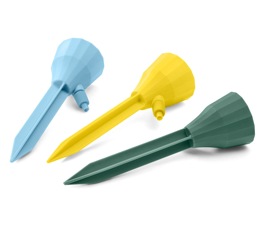 Trois bâtons d’irrigation automatiques bleus, jaunes et verts sont posés sur un fond blanc.