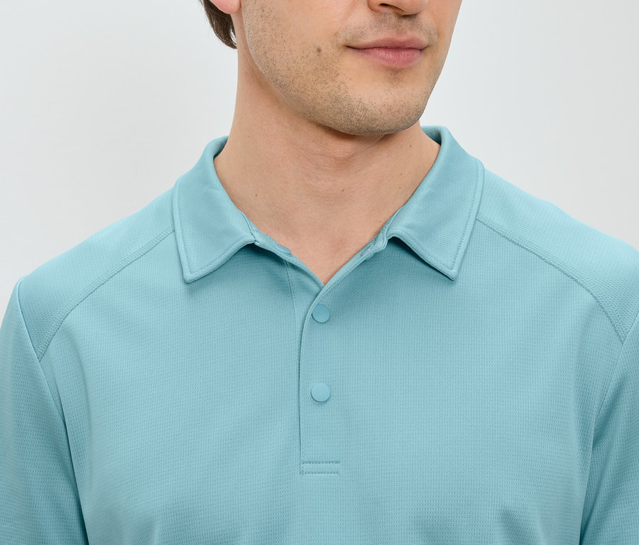 Gros plan d'un homme portant un polo bleu clair.