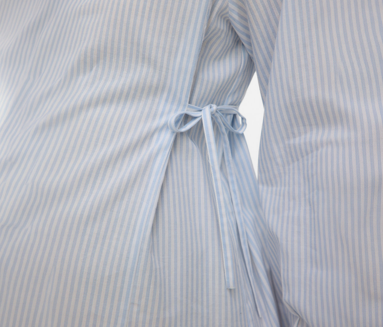 Gros plan sur une robe chemise MAMALICIOUS «	MLLETICIA LIA	» à rayures bleu clair avec cordon de serrage.