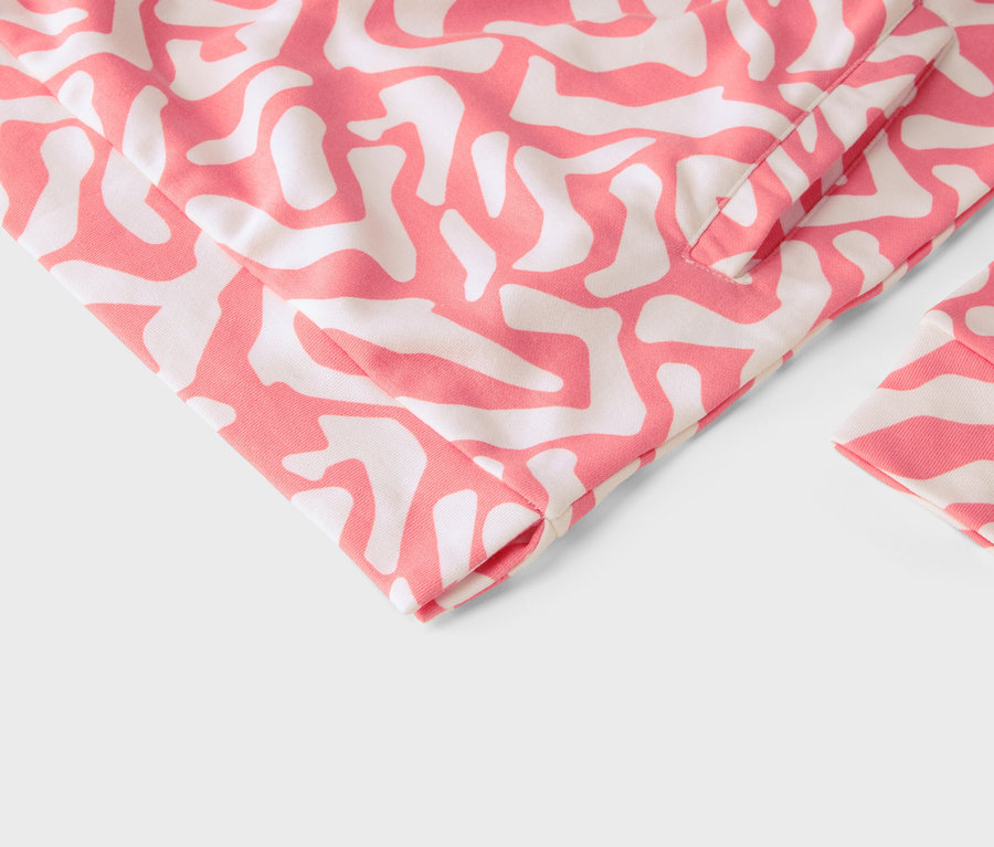 Gros plan d'un vêtement à motif abstrait rose et blanc.