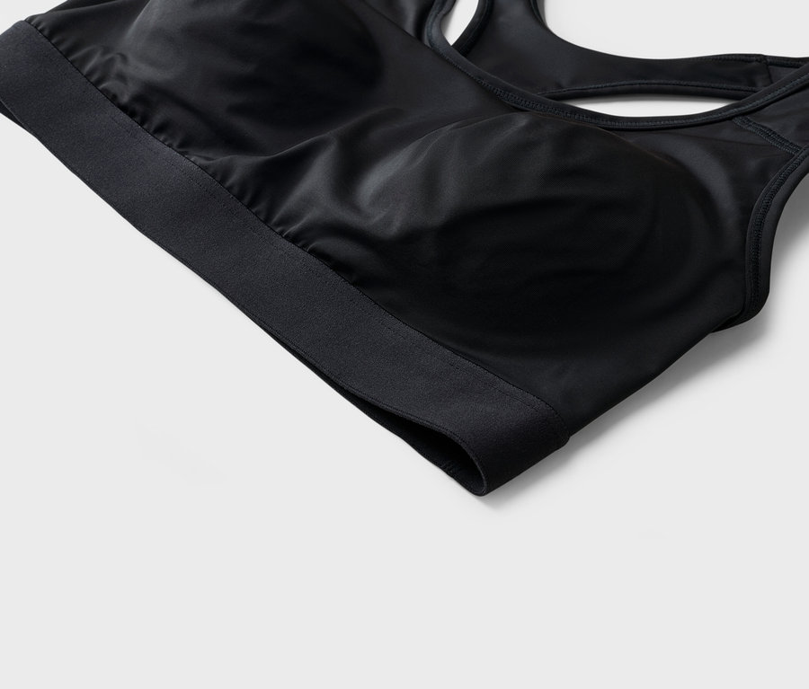 Gros plan d'un soutien-gorge de sport noir avec une large bande inférieure.