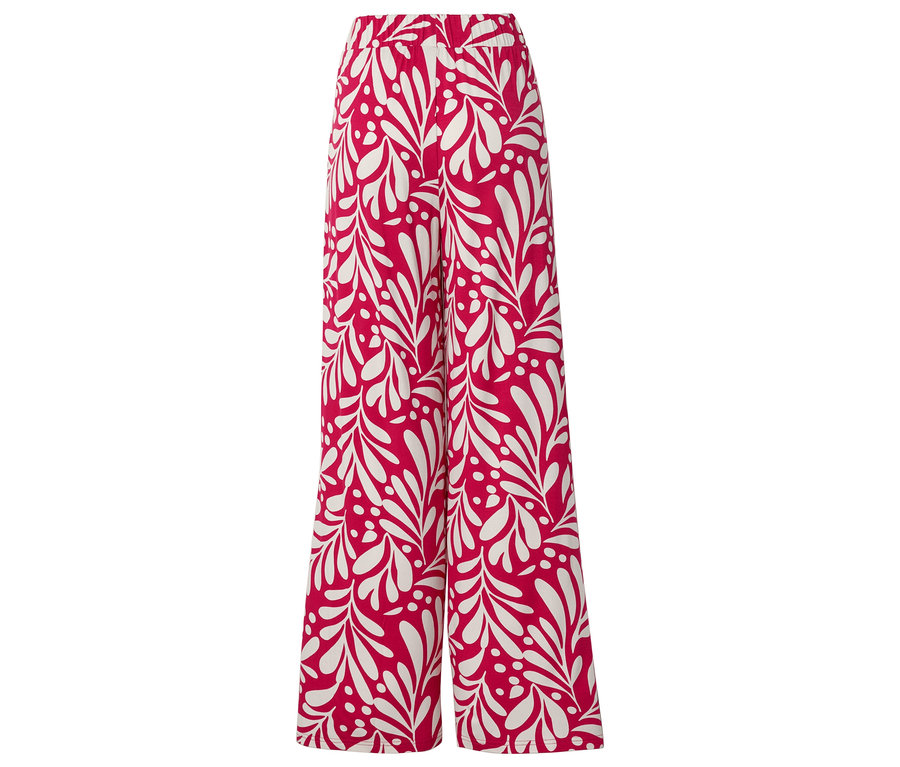 Un long pantalon rouge avec un motif de feuilles blanches est posé sur une surface plane.