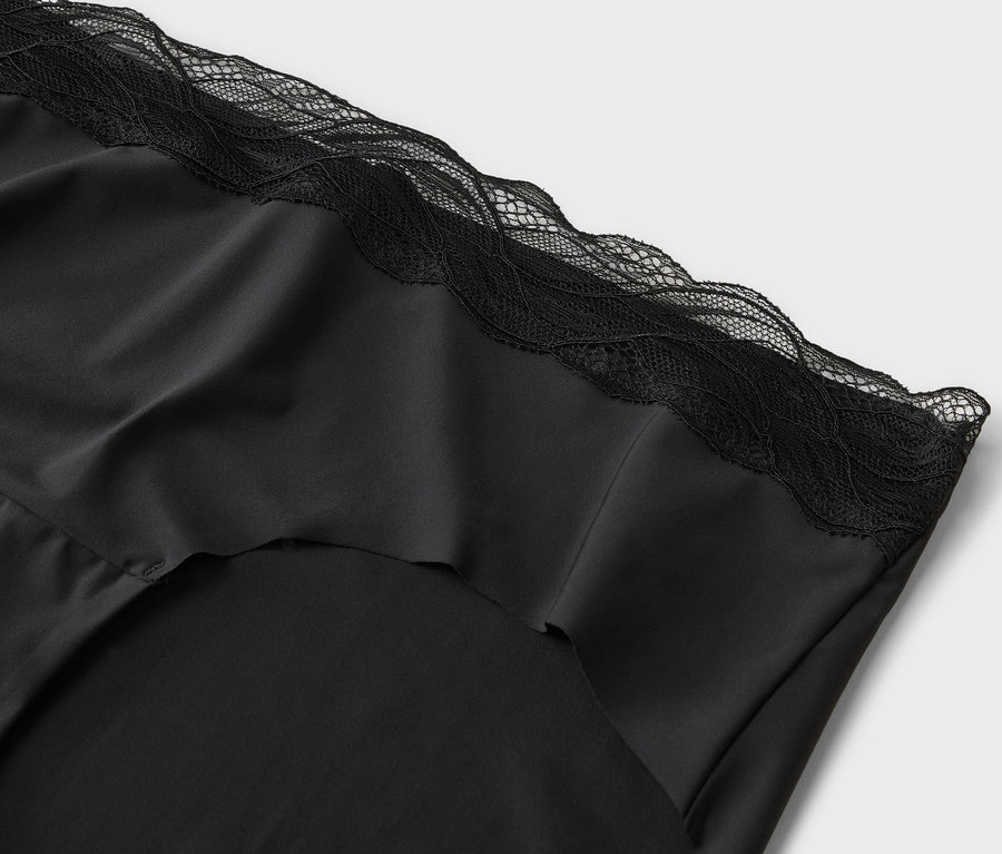 Gros plan sur un haut en soie noire avec des détails en dentelle.