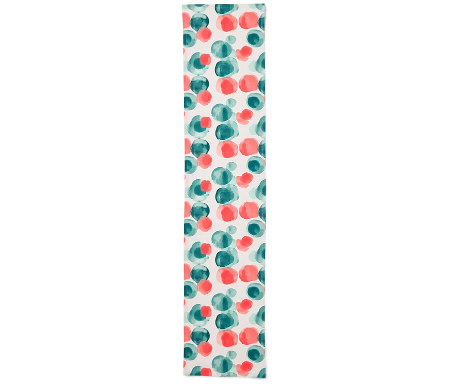 Un chemin de table avec un motif de points rouges et verts sur un fond blanc.