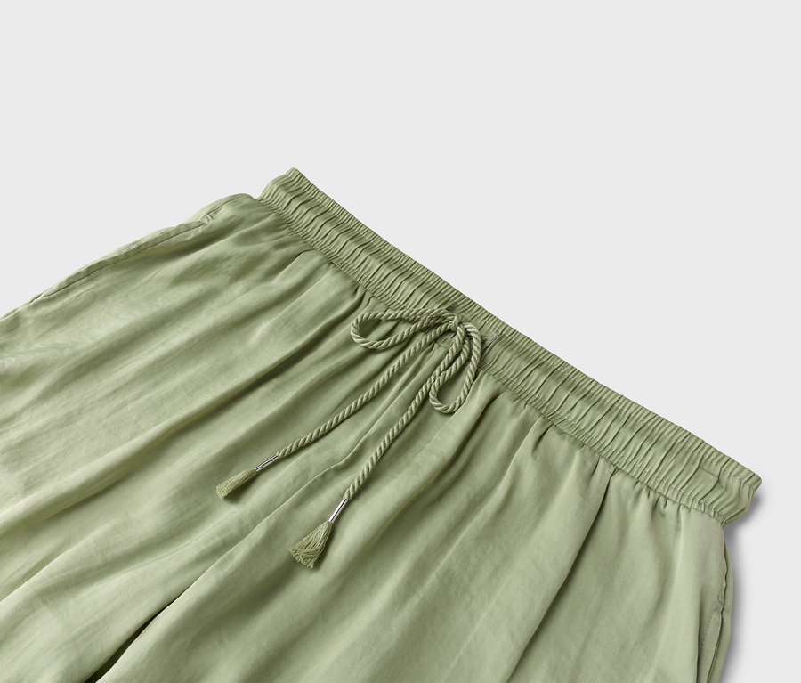 Gros plan d'un pantalon vert clair avec cordon de serrage.