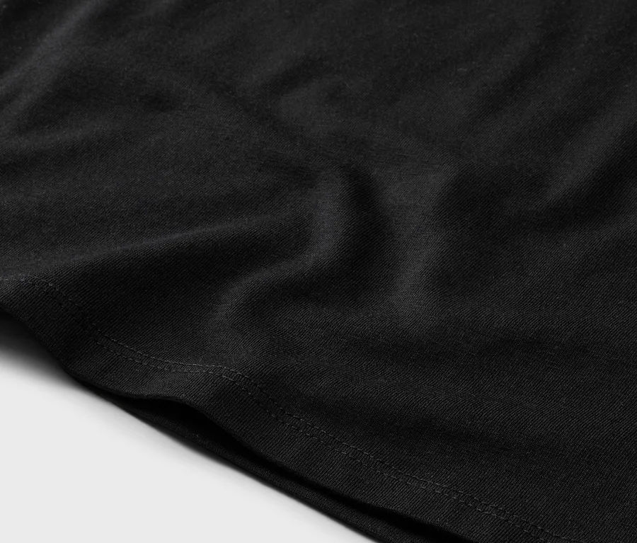 Gros plan d'un tissu noir avec une couture visible sur l'ourlet.