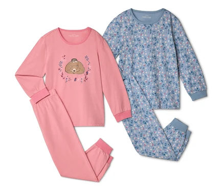 Deux pyjamas sont côte à côte, l'un rose avec un ours et un hérisson, l'autre bleu à motifs floraux.
