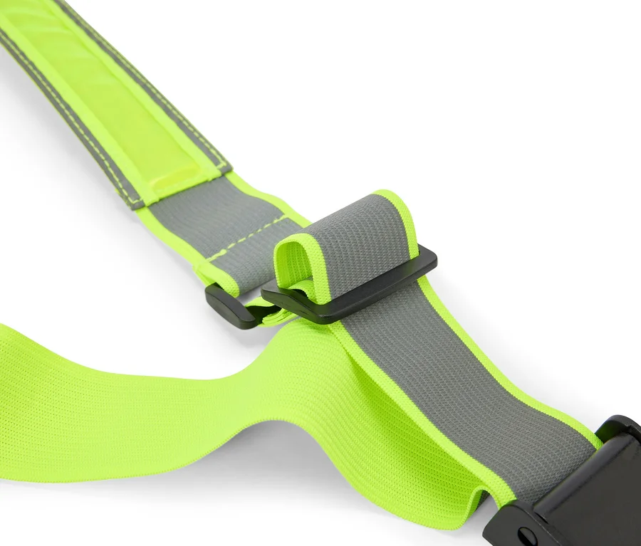 Gros plan d'une sangle réfléchissante jaune fluo avec des boucles noires sur fond blanc.