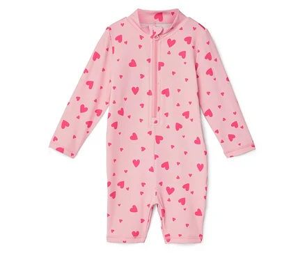 Un maillot de bain rose clair à manches longues et à fermeture éclair intégrale est imprimé de cœurs rouges.