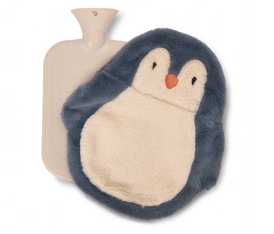 Bouillotte beige avec une housse en peluche en forme de pingouin gris-bleu au ventre crème et au bec orange.