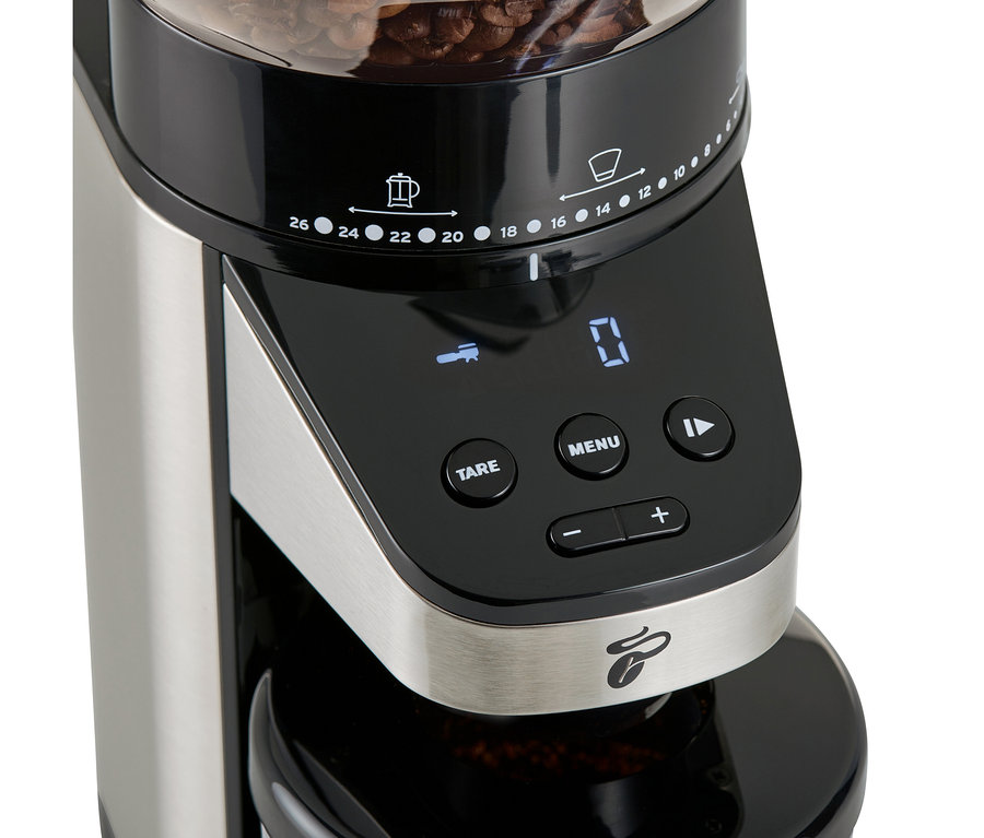 Gros plan d'un moulin à café électrique avec balance, avec des grains de café sur le dessus.