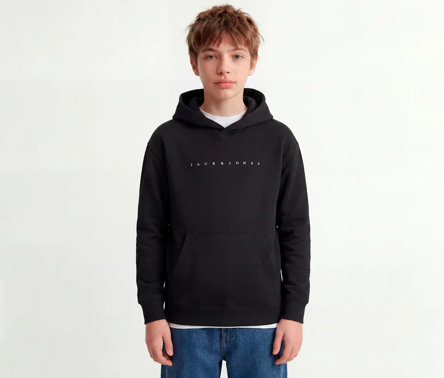 Jeune personne portant un sweat à capuche noir Jack&Jones Star avec logo blanc et un jean bleu.