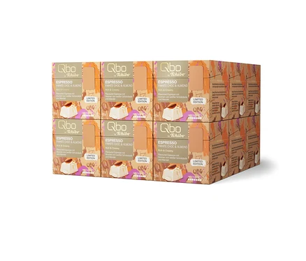 Douze paquets de capsules de café Qbo by Tchibo Espresso White Choc & Almond, édition limitée, empilés en deux rangées.