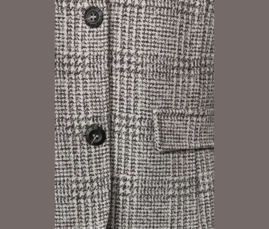 Gros plan d'un blazer Street One à carreaux gris et blanc, avec des boutons noirs et une poche à rabat.